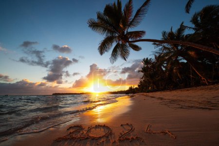 Foto de Feliz Año Nuevo 2024 concepto, letras en la playa tropical Punta Cana. Texto escrito en la playa al amanecer. - Imagen libre de derechos