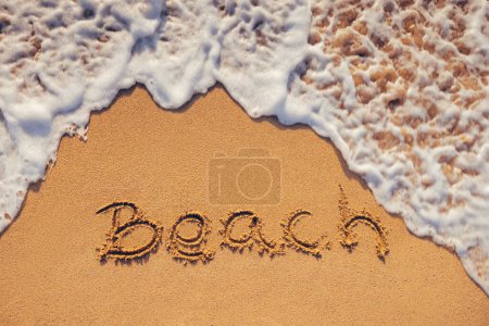 Foto de Playa texto escrito a mano en la arena de la costa de la isla tropical y la ola oceánica como fondo de la naturaleza - Imagen libre de derechos