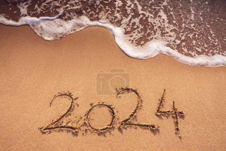 Téléchargez les photos : Bonne année 2024 texte écrit sur la plage sable et Caraïbes bleu vagues de mer, Voyage et mode de vie concept - en image libre de droit