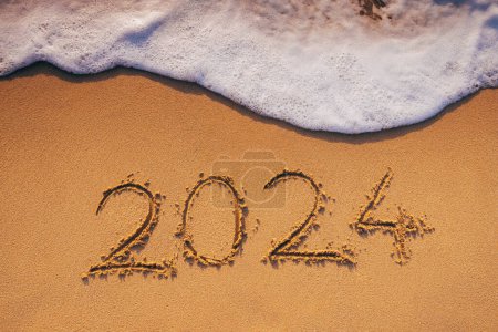 Foto de 2024 texto en la arena del mar y la ola en la playa del océano orilla - Imagen libre de derechos