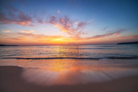 Foto de Hermoso amanecer con paisaje nublado sobre el mar y la playa, puesta de sol panorámica del océano - Imagen libre de derechos