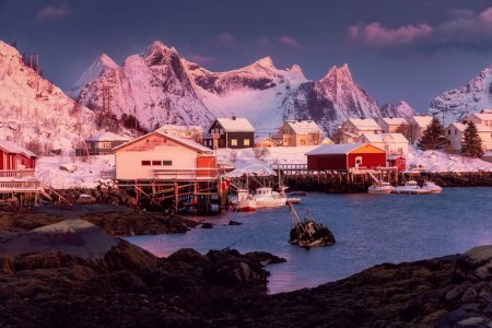 Foto de Pueblo pesquero noruego con casas de rorbu rojo, picos de montaña y costa marina invierno puesta del sol paisaje, islas Lofoten, Noruega - Imagen libre de derechos