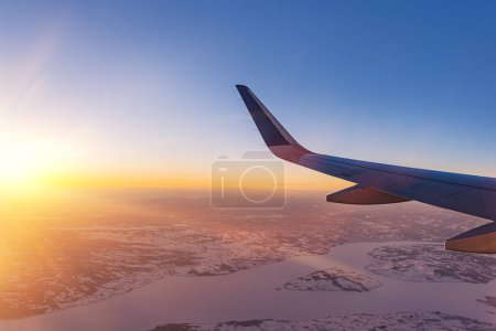 Foto de Avión volando bajo sobre montañas nevadas y preparándose para aterrizar en el aeropuerto, vista desde la ventana del avión de la turbina del ala y el horizonte - Imagen libre de derechos