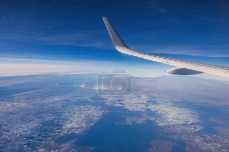 Foto de Avión volando sobre montañas nevadas paisaje en un día soleado, vista desde la ventana del avión de nubes y turbinas de alas - Imagen libre de derechos