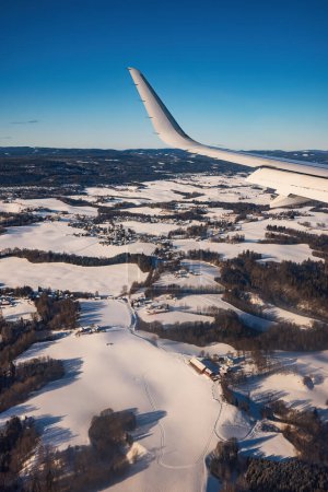 Foto de Avión volando bajo sobre montañas nevadas y preparándose para aterrizar en el aeropuerto, vista desde la ventana del avión de la turbina del ala y el horizonte - Imagen libre de derechos