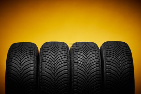 Foto de Neumáticos de coche, ruedas de invierno aisladas sobre fondo amarillo - Imagen libre de derechos