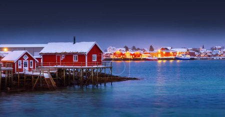 Foto de Luces nocturnas escénicas de las islas Lofoten, Noruega, Reine y casas rojas en el pueblo de pescadores en una orilla del mar - Imagen libre de derechos