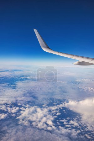 Foto de Avión volando sobre nubes de cielo de color durante el atardecer escénico o el amanecer paisaje nublado, vista desde la ventana plana de las turbinas de alas y el horizonte - Imagen libre de derechos