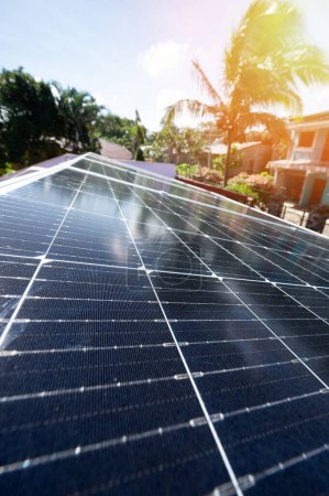 Solar panel energy system of house roof with bright tropical sun background