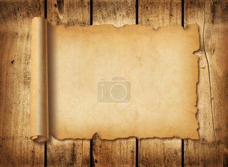Foto de Hoja de papel medieval antigua. Desplazamiento horizontal del pergamino sobre un fondo de tablero de madera - Imagen libre de derechos