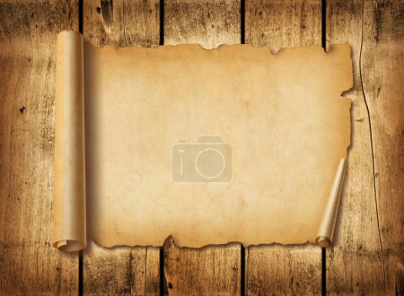 Foto de Hoja de papel medieval antigua. Desplazamiento horizontal del pergamino sobre un fondo de tablero de madera - Imagen libre de derechos