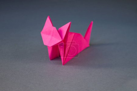 Foto de Pink paper cat origami isolated on a blank grey background. - Imagen libre de derechos