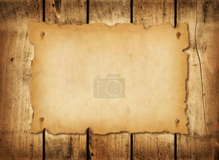 Téléchargez les photos : Vieille feuille de papier médiévale. Parchemin horizontal en parchemin sur un fond de planche de bois - en image libre de droit
