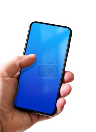 Téléchargez les photos : Main tenant un smartphone avec écran bleu vierge. Isolé sur fond blanc. - en image libre de droit