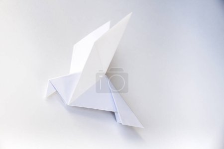 Téléchargez les photos : Origami de colombe en papier isolé sur un fond blanc vierge. - en image libre de droit