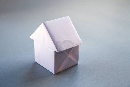 Foto de Papel blanco casa origami aislado sobre un fondo gris en blanco. - Imagen libre de derechos