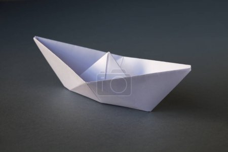 Téléchargez les photos : Origami bateau en papier blanc isolé sur un fond blanc gris. - en image libre de droit