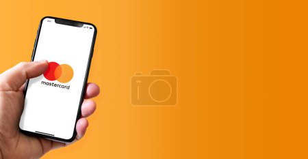 Photo for Paris - France - March 15, 2022 : Hand holding iphone smartphone with MasterCard logo. Horizontal banner - Royalty Free Image