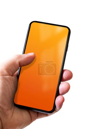Téléchargez les photos : Main tenant un smartphone avec écran orange vierge. Isolé sur fond blanc. - en image libre de droit