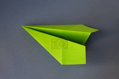 Photo for Green paper plane origami isolated on a blank grey background - Royalty Free Image