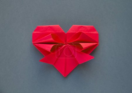 Foto de Origami corazón de papel rojo aislado sobre un fondo gris en blanco. Tarjeta de San Valentín - Imagen libre de derechos