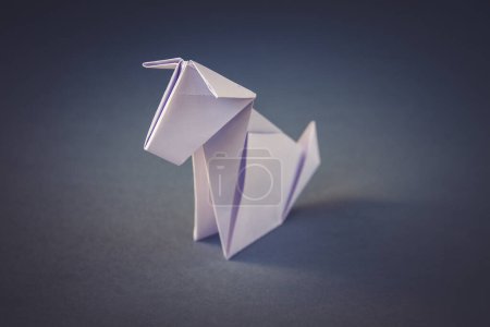 Foto de Papel blanco origami de perro aislado sobre un fondo gris en blanco. - Imagen libre de derechos