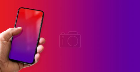 Photo for Hand holding a smartphone with blank red and purple screen. Colorful background. Horizontal banner. - Royalty Free Image