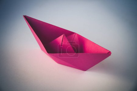 Foto de Pink paper boat origami isolated on a blank white background. - Imagen libre de derechos