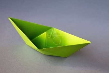 Photo for Green paper boat origami isolated on a blank grey background. - Royalty Free Image