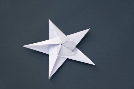 Téléchargez les photos : Origami étoile en papier blanc isolé sur un fond blanc gris. - en image libre de droit