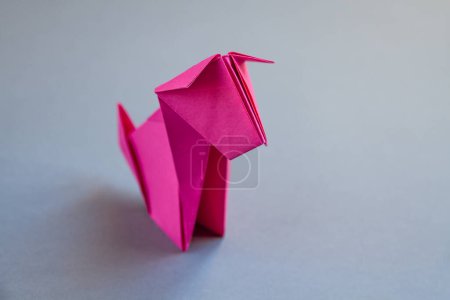 Foto de Origami de perro de papel rosa aislado sobre un fondo gris en blanco. - Imagen libre de derechos