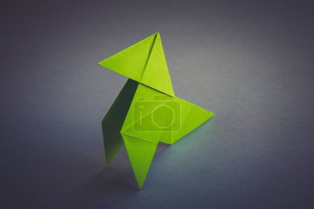 Foto de Papel verde gallina origami aislado sobre un fondo gris en blanco. Cocotte en papier - Imagen libre de derechos
