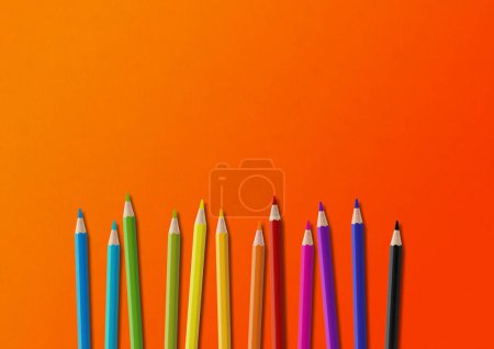 Téléchargez les photos : Crayon coloré en bois isolé sur orange. Contexte horizontal. - en image libre de droit