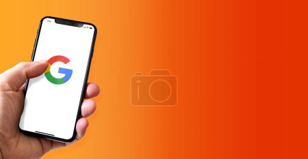 Photo for Paris - France - March 15, 2022 : Hand holding iphone smartphone with Google logo. Horizontal banner - Royalty Free Image