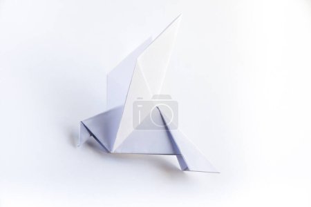 Téléchargez les photos : Origami de colombe en papier isolé sur un fond blanc vierge. - en image libre de droit