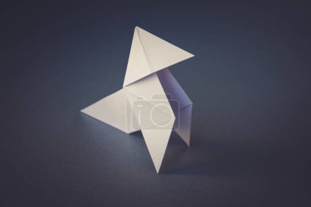 Téléchargez les photos : Origami de poule de papier blanc isolé sur un fond gris blanc. Cocotte en papier - en image libre de droit