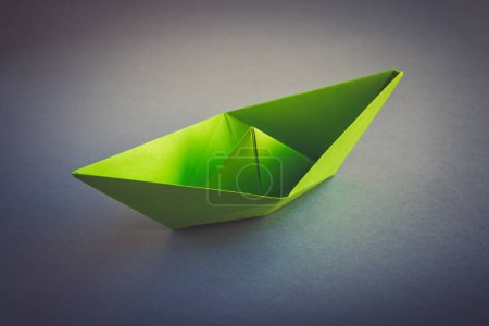 Téléchargez les photos : Papier vert bateau origami isolé sur un fond blanc gris. - en image libre de droit