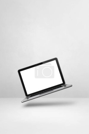 Téléchargez les photos : Ordinateur portable vierge flottant sur un fond blanc. Illustration 3D isolée. Modèle vertical - en image libre de droit