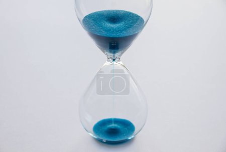 Foto de Reloj de arena azul aislado sobre fondo blanco. Concepto de paso del tiempo - Imagen libre de derechos