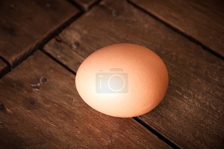Photo for Fresh egg on a rustic wooden board background - Royalty Free Image