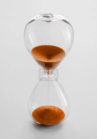 Photo for Hourglass containing orange sand isolated on white background. Concept of time passing - Royalty Free Image