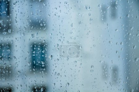 Téléchargez les photos : La pluie tombe sur une fenêtre. Fond d'écran abstrait - en image libre de droit