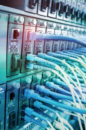 Foto de Cables de fibra óptica conectados a puertos ópticos y cables de red conectados a puertos Ethernet - Imagen libre de derechos