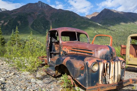 Photo for An array of abandoned rusty post war trucks that lay rusting away in the wilderness during summer time in northern Canada - Royalty Free Image