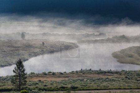 Téléchargez les photos : Lac de montagne brumeux tôt le matin serein dans les montagnes. - en image libre de droit