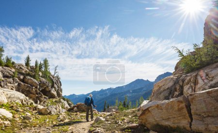 Photo for Hiker in mountains on beautiful rock background - Royalty Free Image