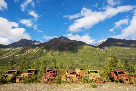 Téléchargez les photos : Une gamme de camions rouillés abandonnés d'après-guerre qui rouillent dans la nature sauvage pendant l'été dans le nord du Canada - en image libre de droit