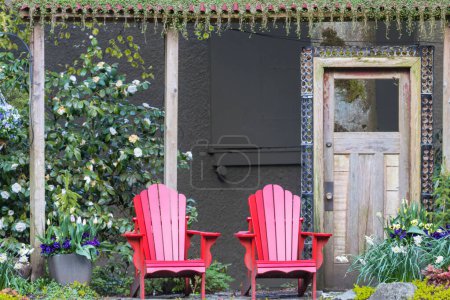 Foto de Red comfortable deck chairs in the spring garden  in Canada. - Imagen libre de derechos