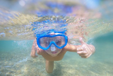 Téléchargez les photos : Un garçon plongeant sous l'eau dans l'océan - en image libre de droit