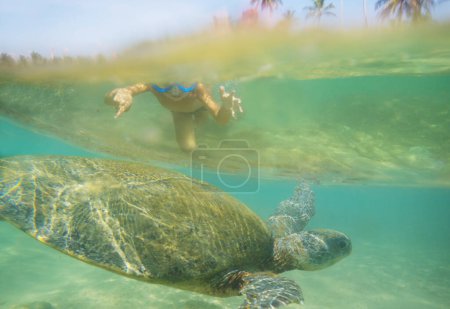 Foto de Niño nadando con una tortuga marina gigante en el océano en Sri Lanka - Imagen libre de derechos
